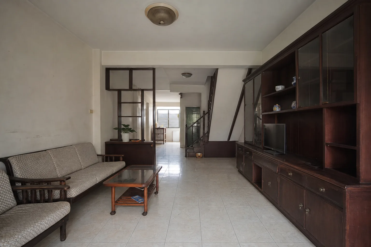 ห้องนั่งเล่นก่อนรีโนเวตที่ค่อนข้างมืดและมีตู้เก็บของขนาดใหญ่